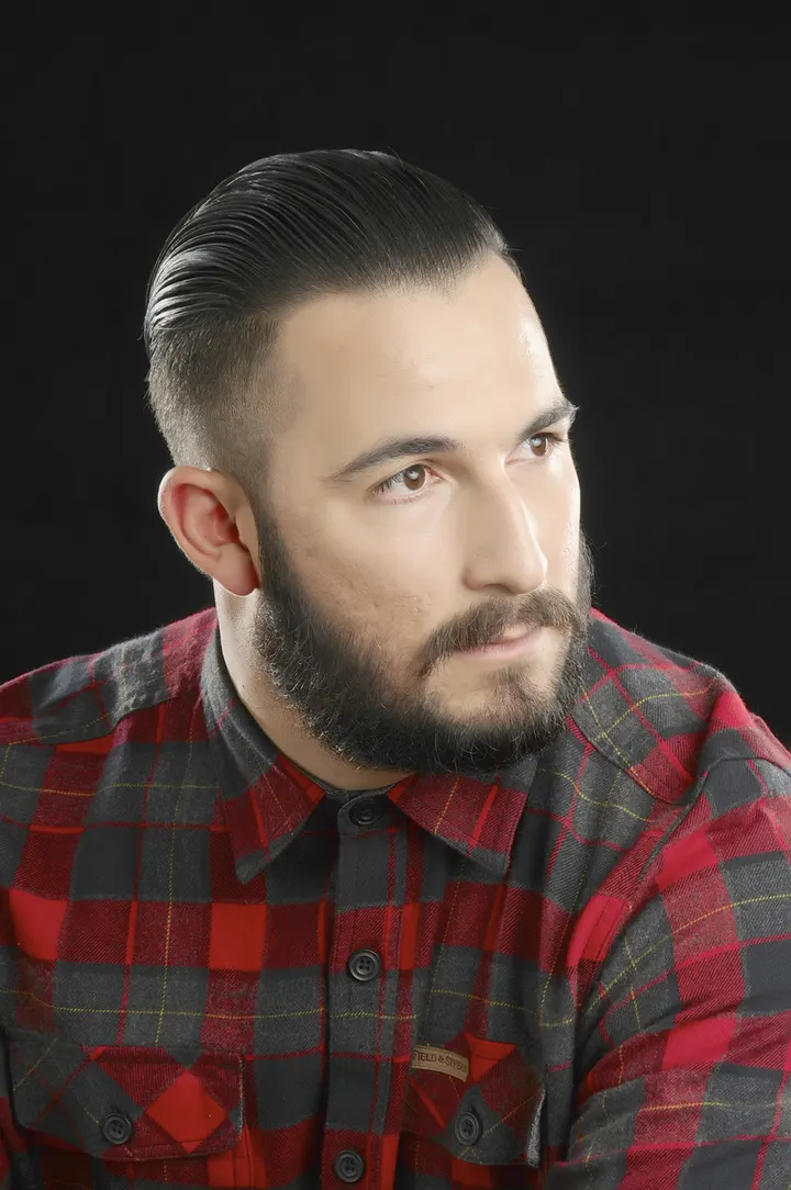 Men's slicked-back cut with a groomed beard