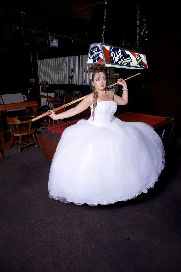 Quinceañera in a white ball gown, hair in a glam updo
